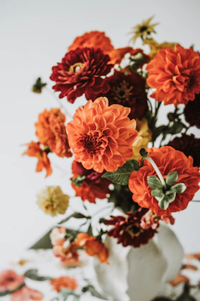 Vibrant bouquet of orange and red dahlias in a vase