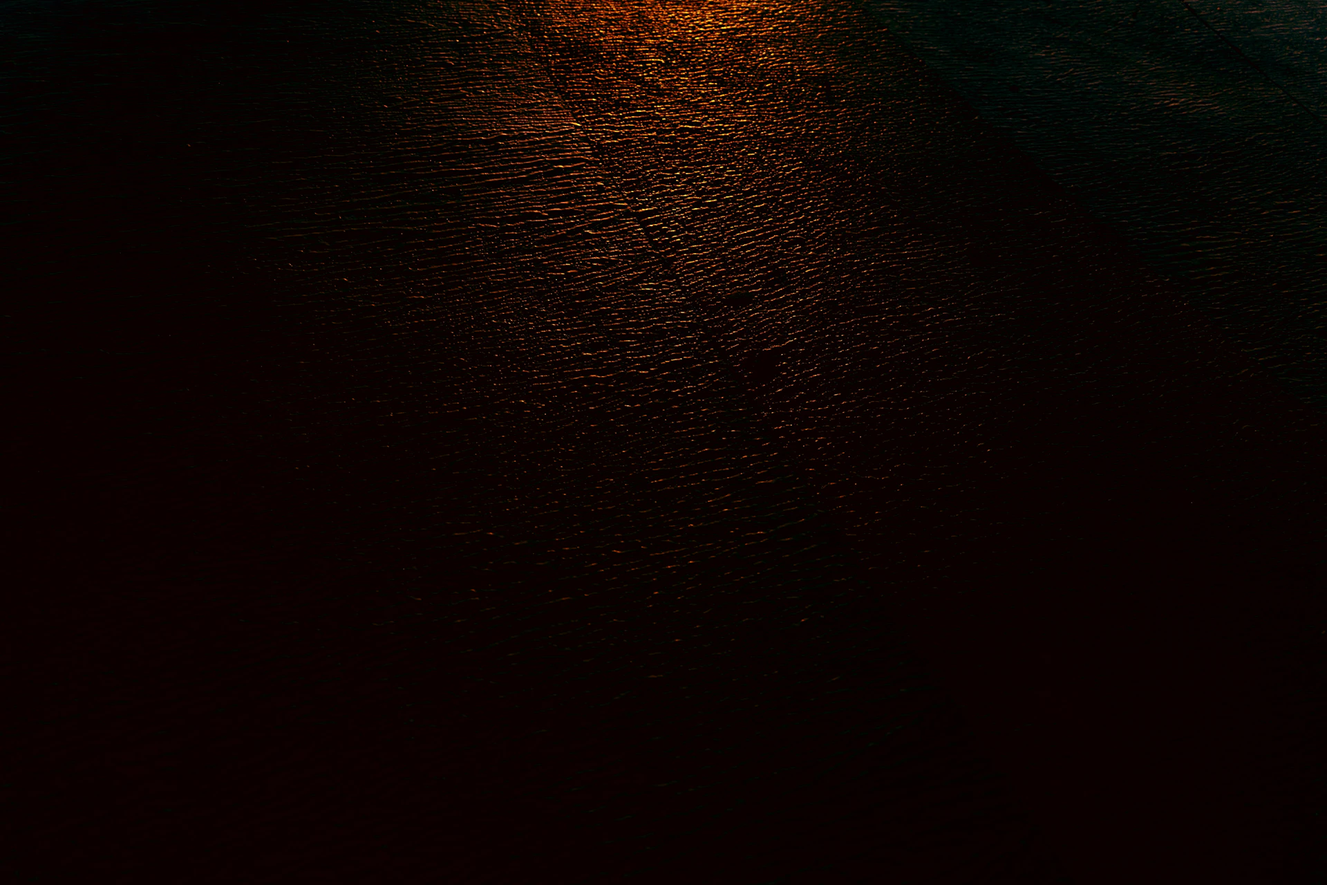 Dark textured surface with warm light reflection