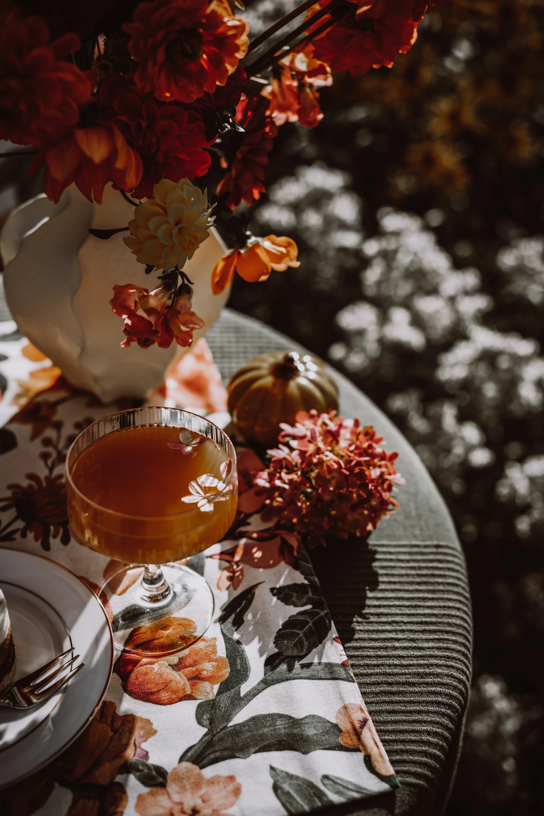 Autumn tabletop detail with flowers, small pumpkins and a seasonal drink