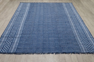 A blue and white striped rug on a wooden floor.
