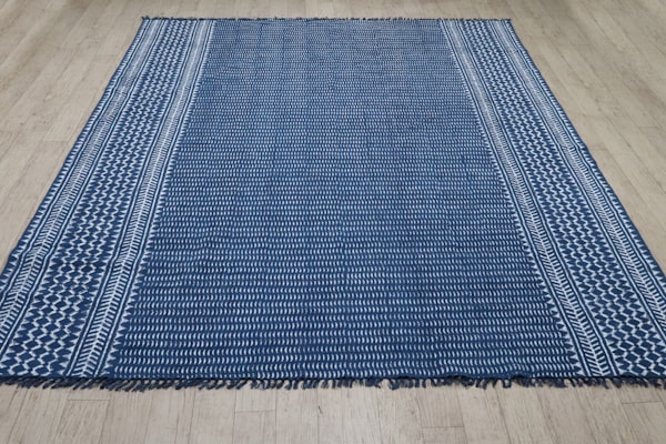 Blue and white striped rug on a wooden floor