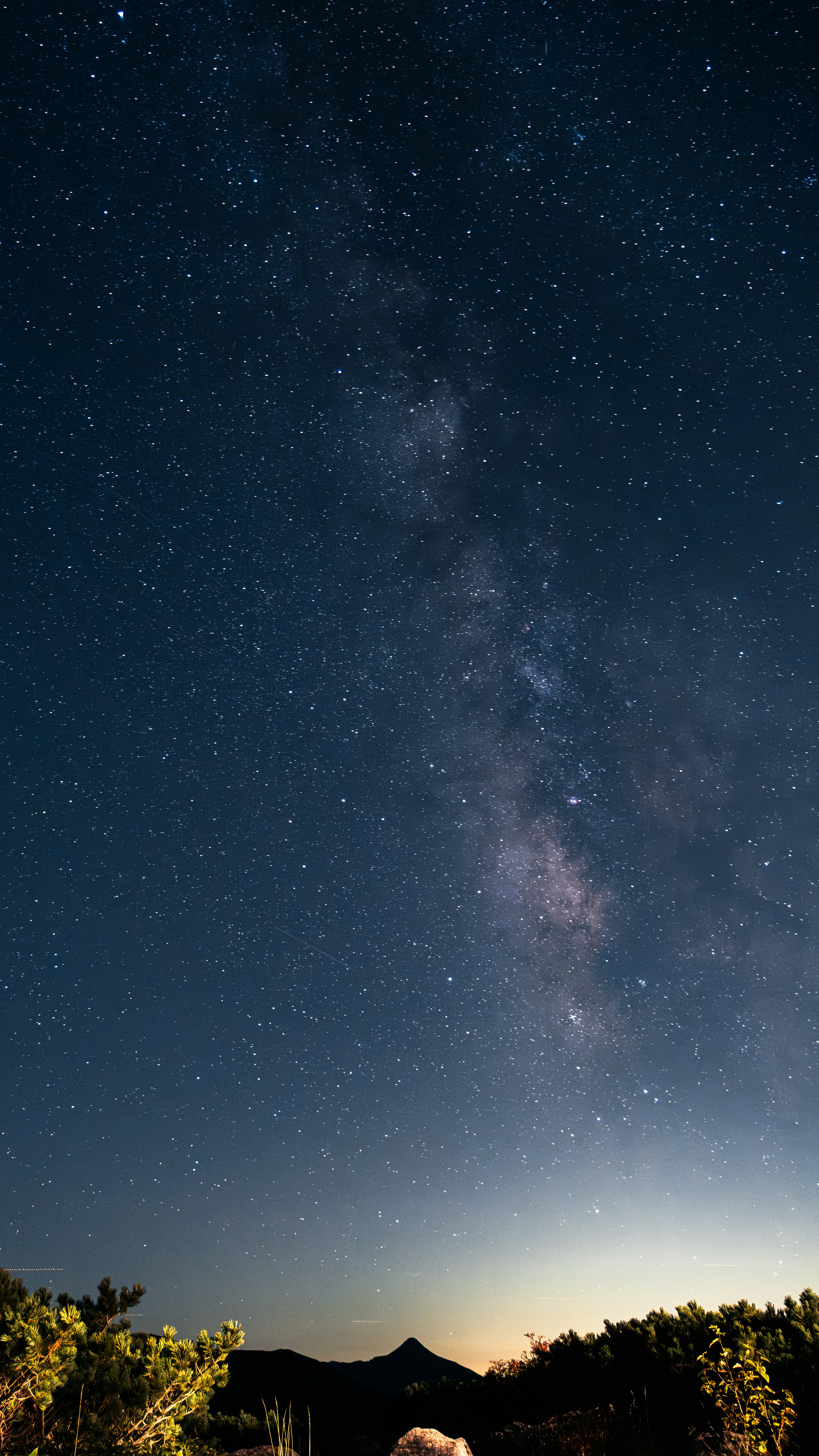 Milky way galaxy over a dark landscape