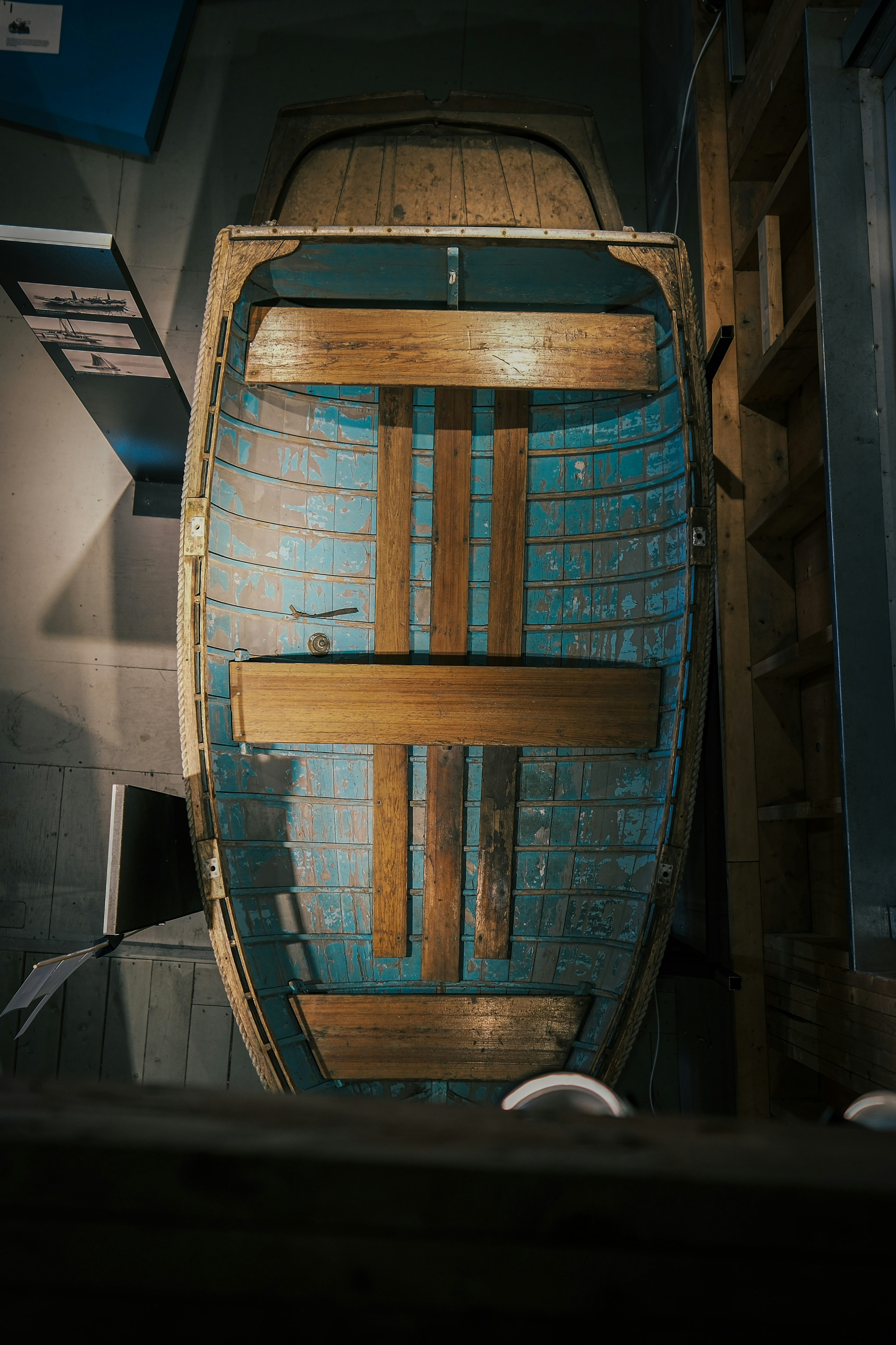 Ein altes hölzernes Ruderboot mit blauer Innenausstattung.