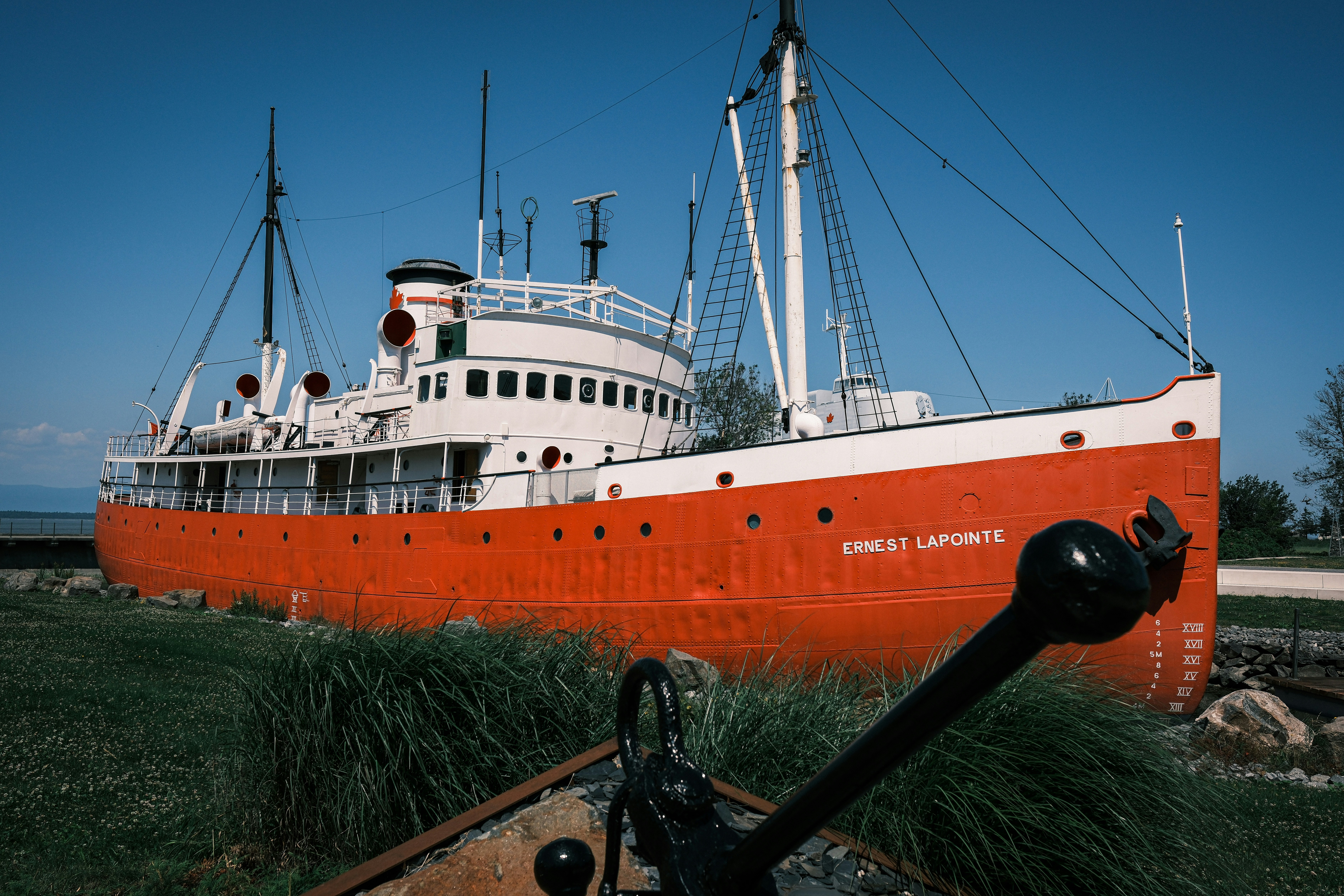 Rot-weißes Schiff an grasbewachsener Küste angedockt
