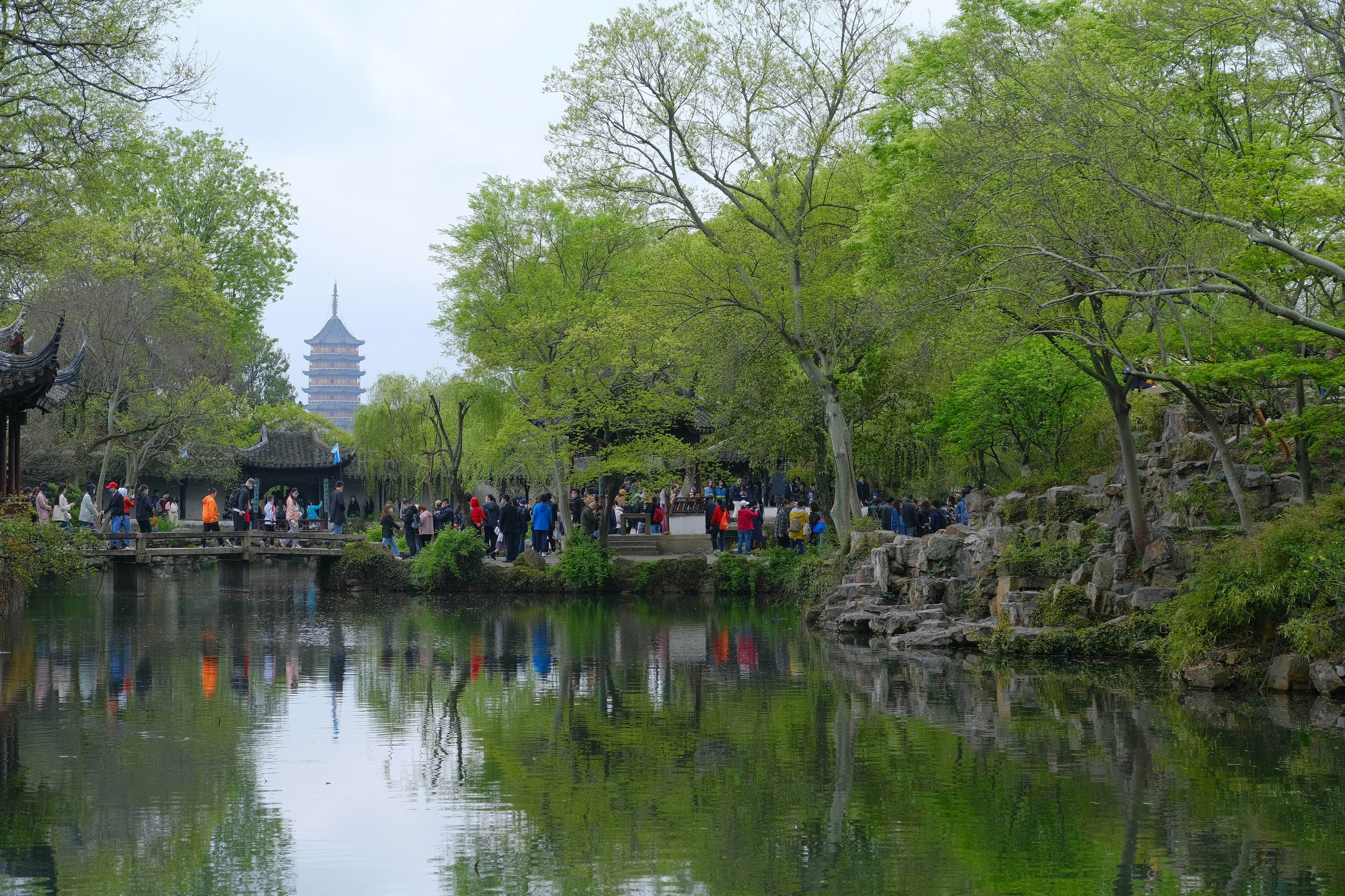Park with a pond, trees, and distant pagoda.