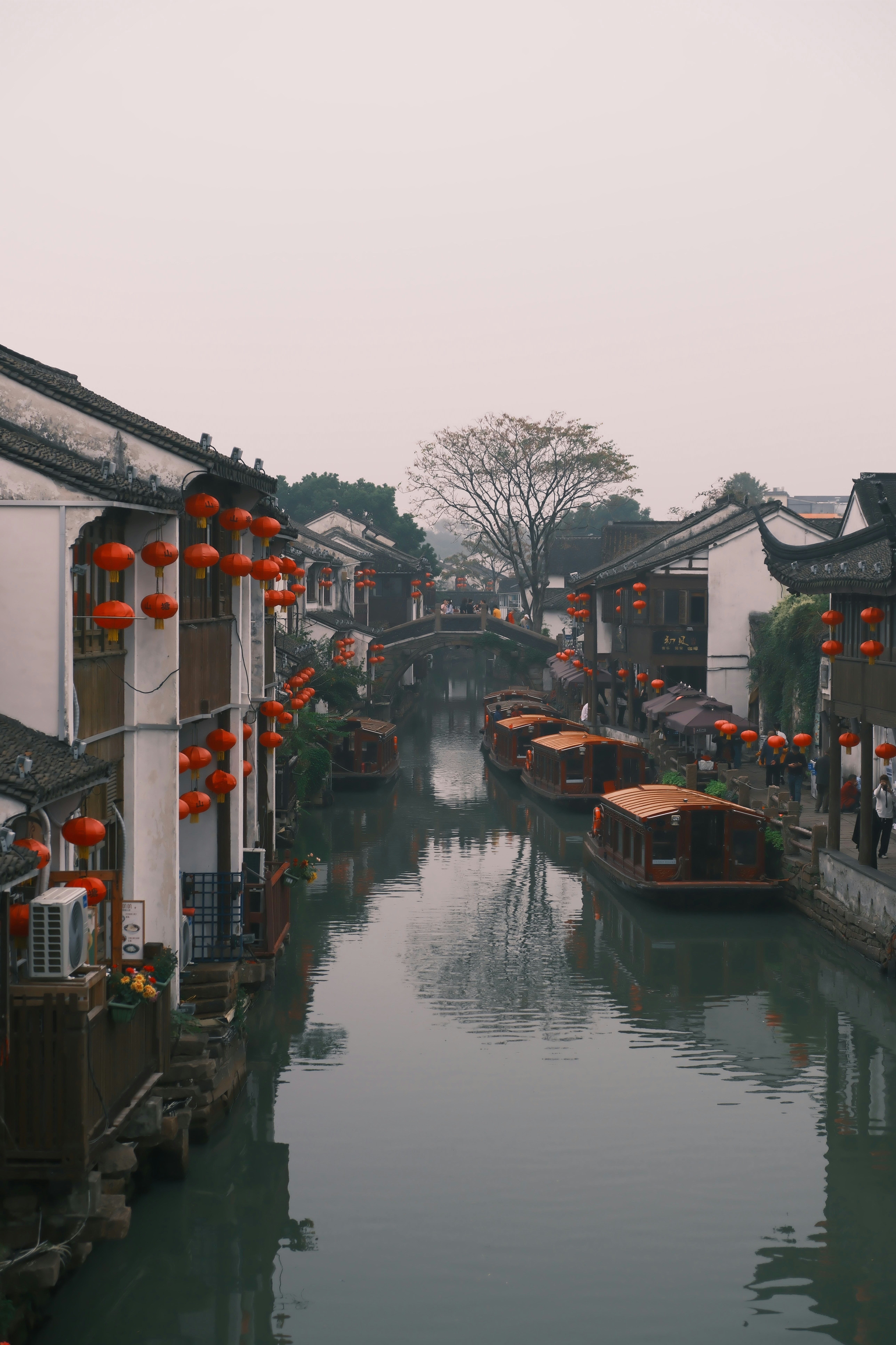Boats line a canal in a historic chinese town.
