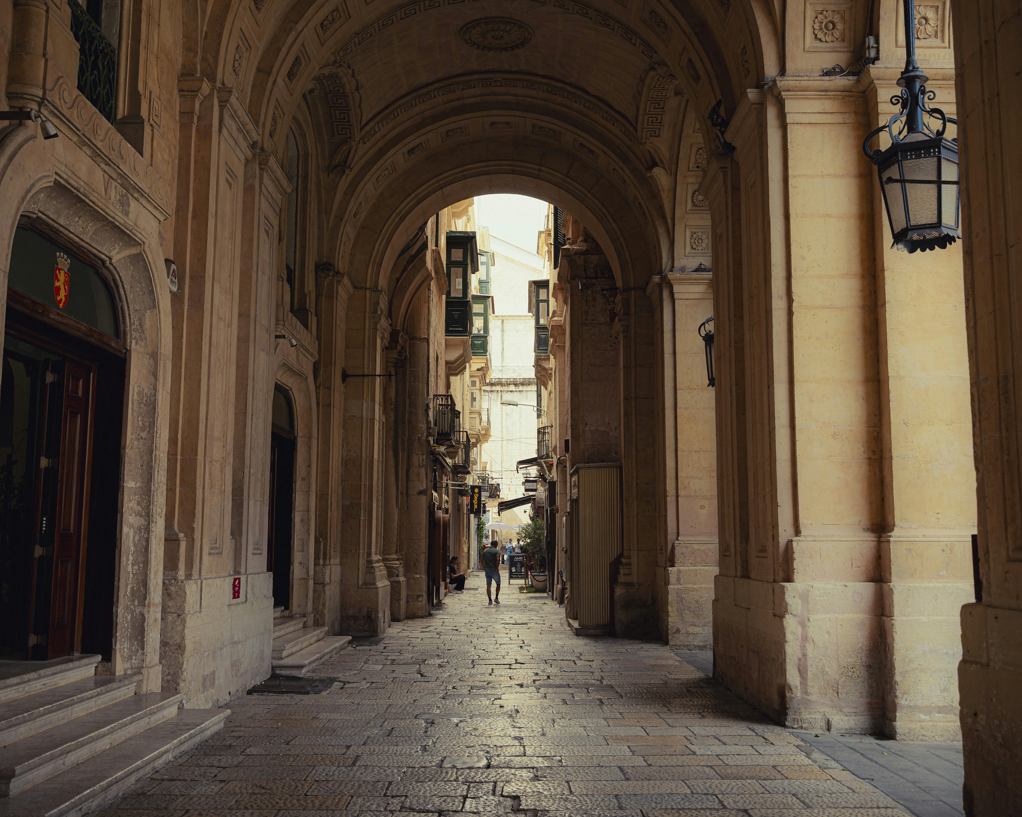 Arched stone passage with people walking in distance