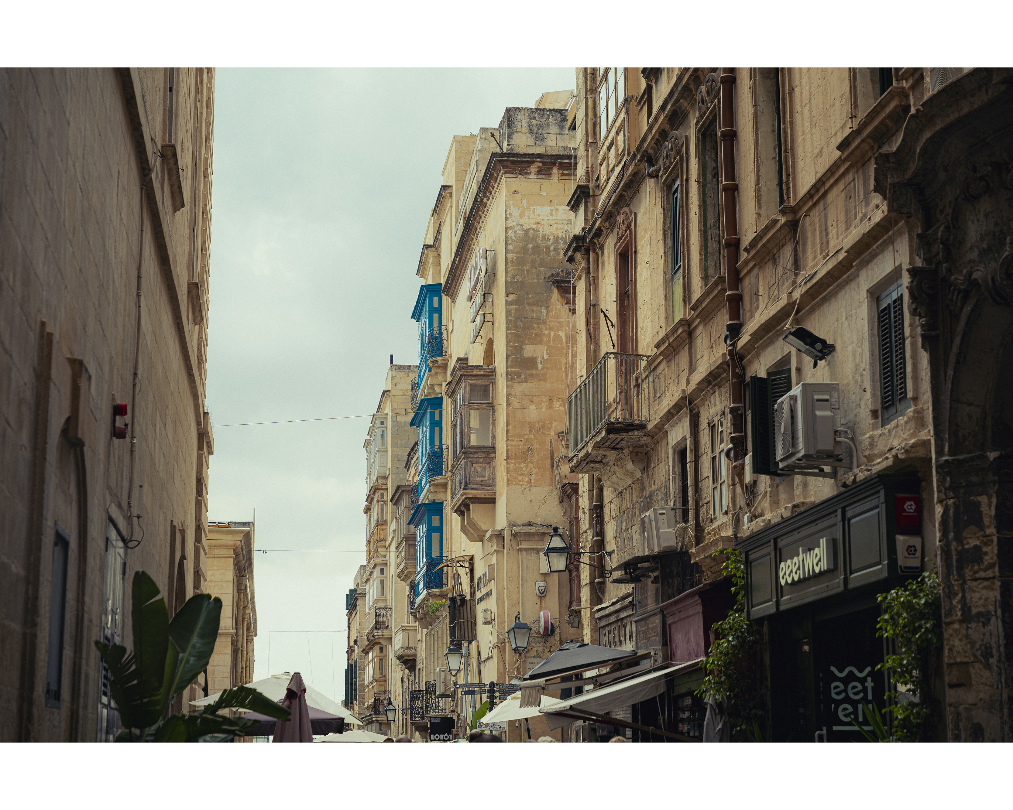 Strada stretta con vecchi edifici e balconi.