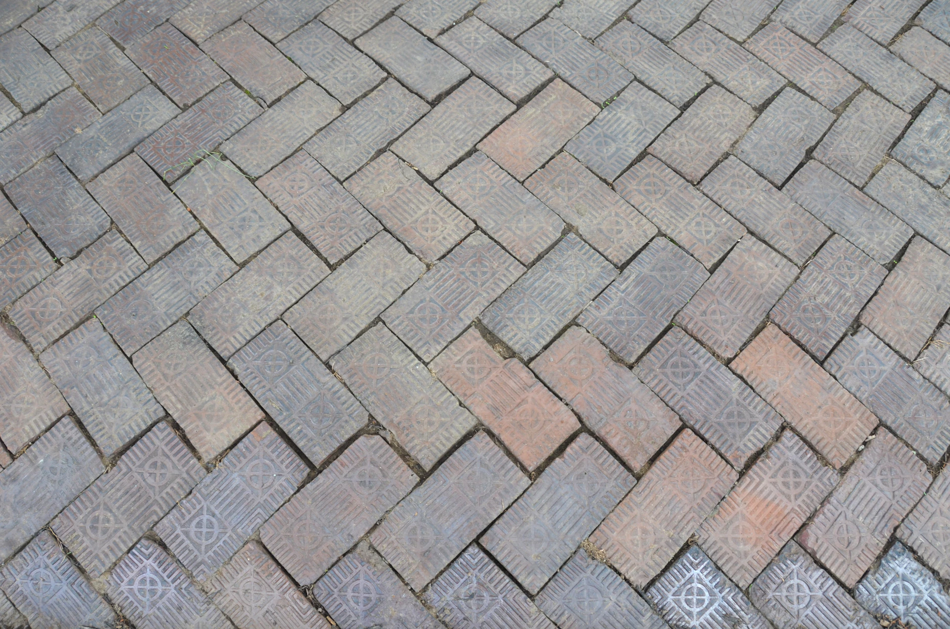 Herringbone pattern of weathered bricks on ground