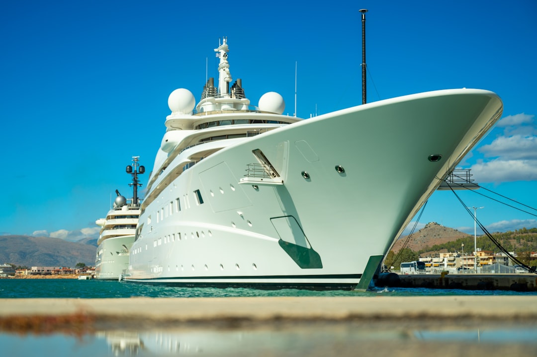 A large white yacht docked in a harbor.
