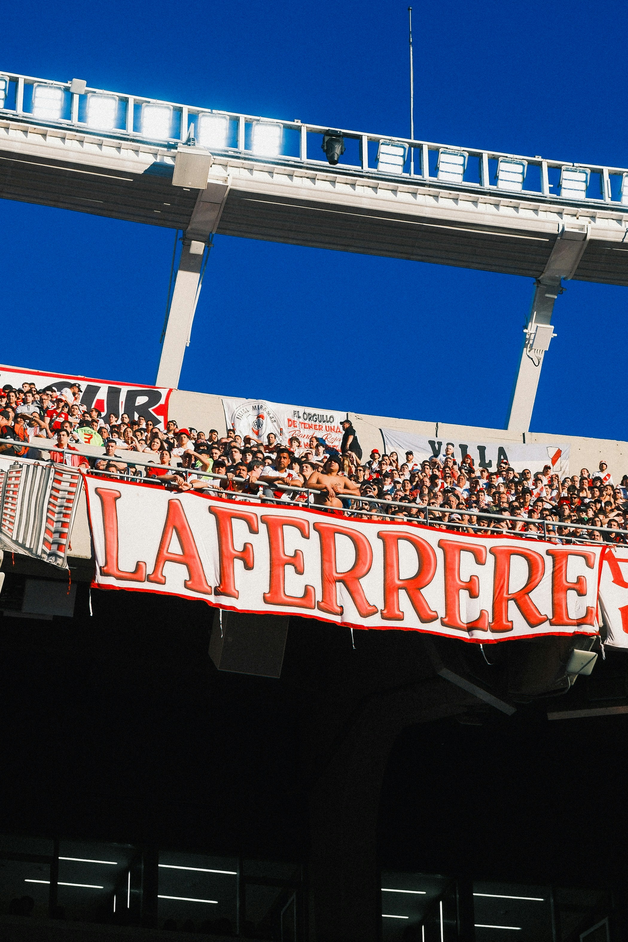 Crowd cheering with a banner at a stadium.