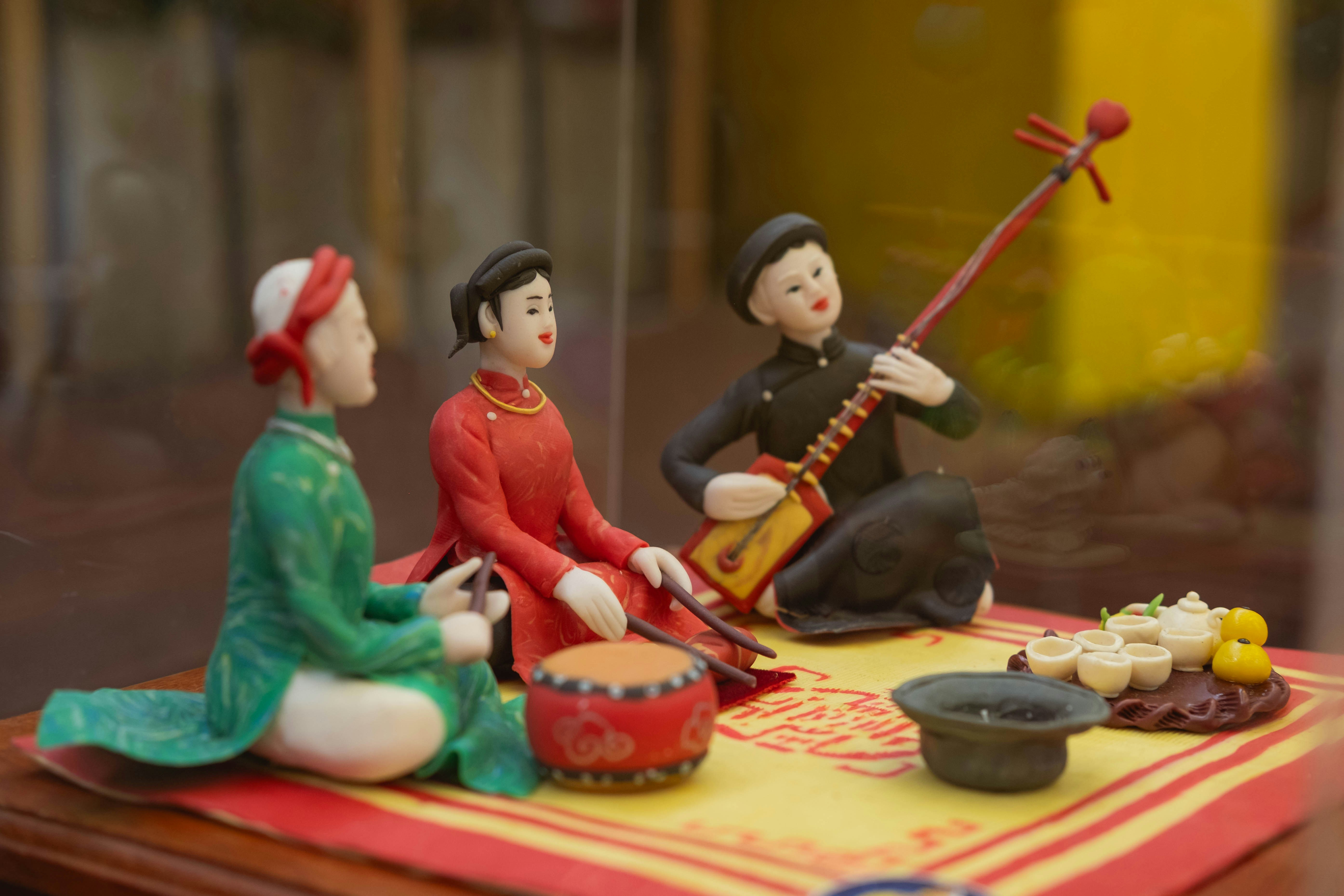 Three figures in traditional clothing playing music.