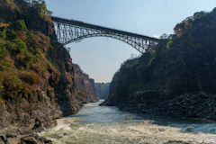 Arch bridge spans a rocky gorge above a river