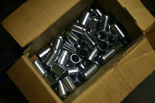 Cardboard box filled with shiny metal cylinders