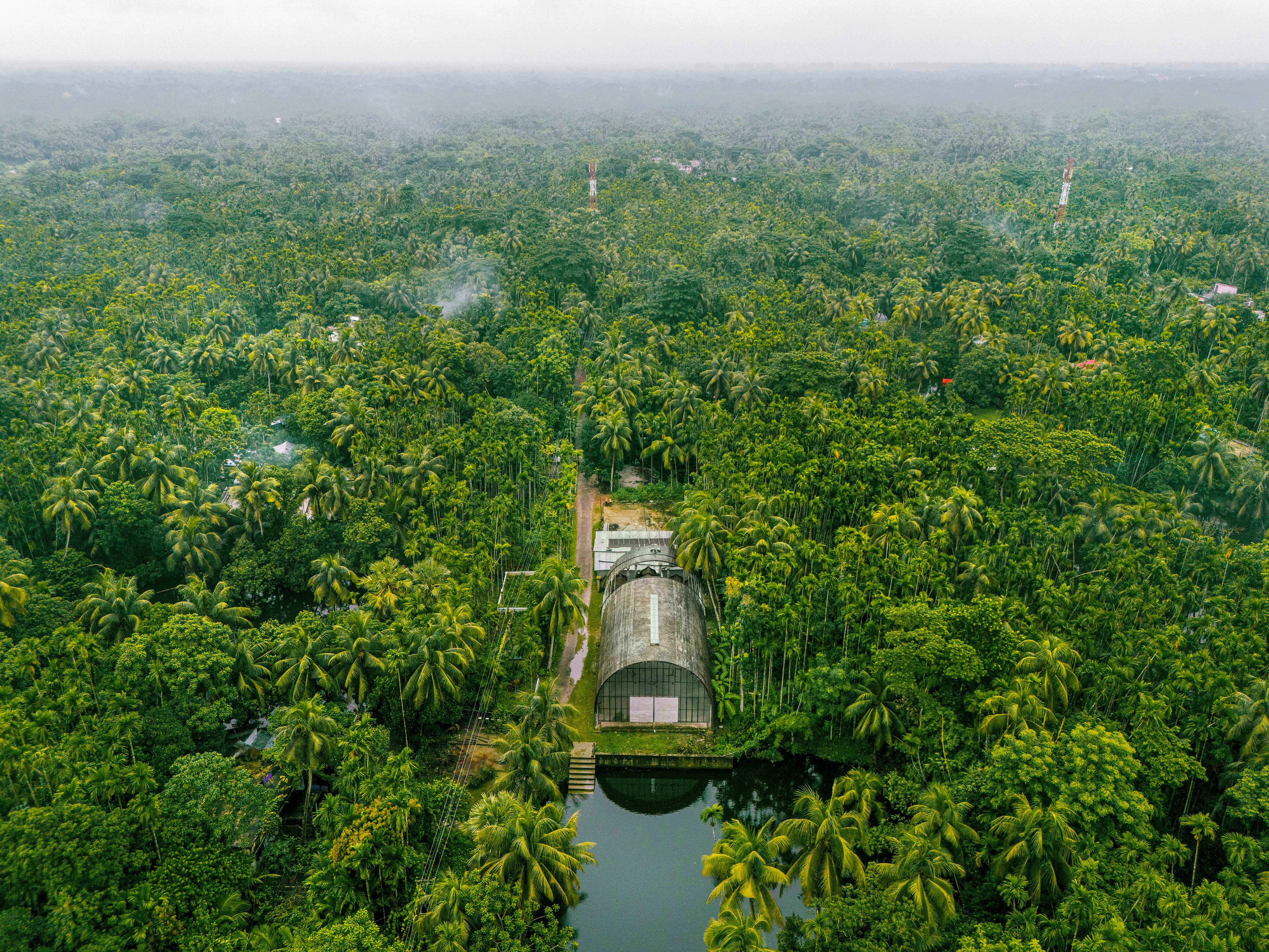Aerial view of a building surrounded by lush green trees.