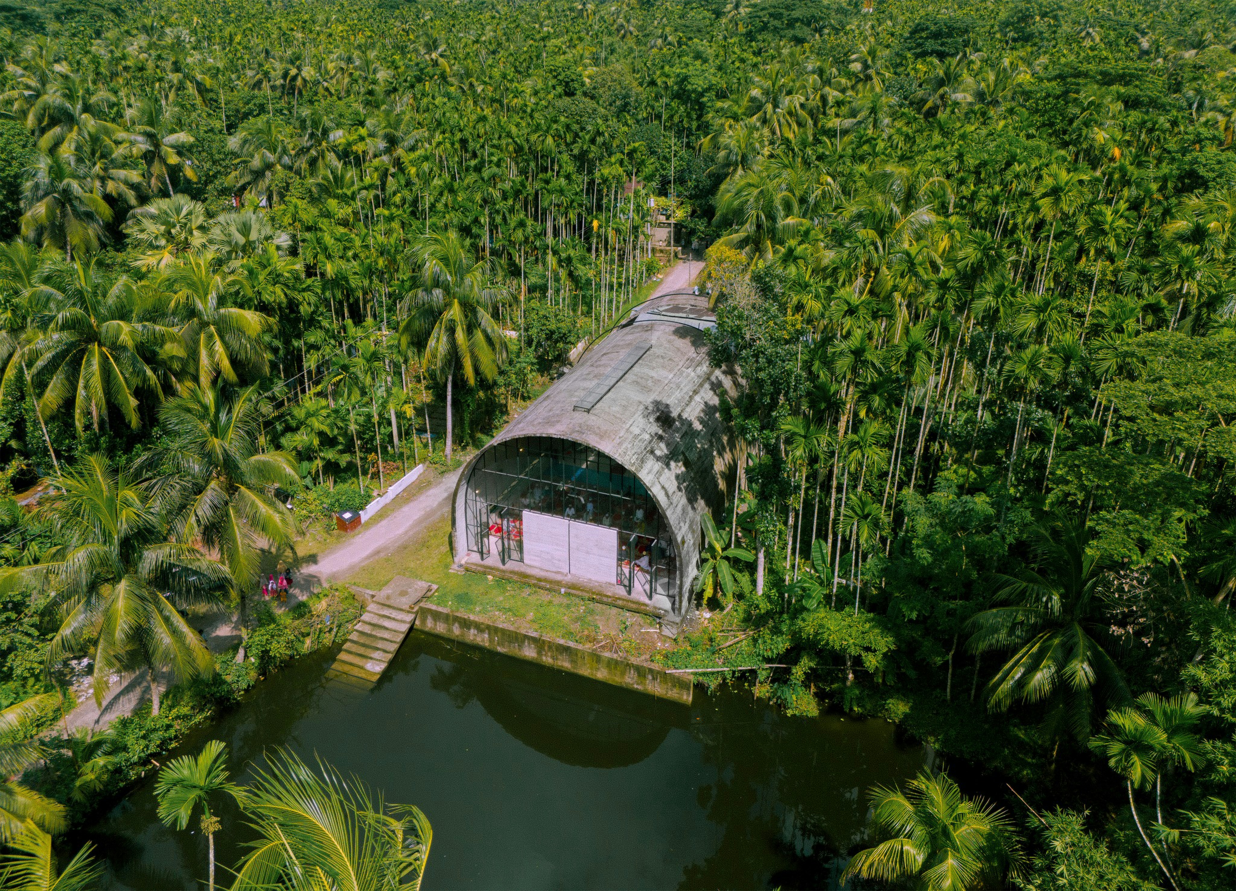 Bâtiment dans une forêt tropicale verdoyante avec étang