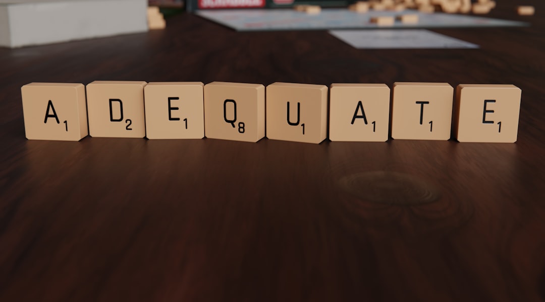 Scrabble tiles spell out the word adequate.
