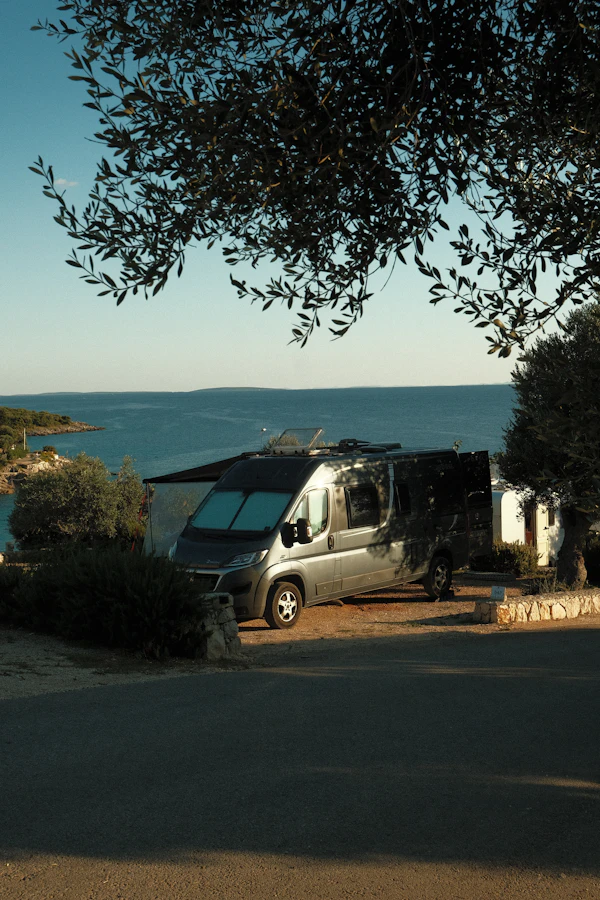 Campervan parked by the sea at sunset