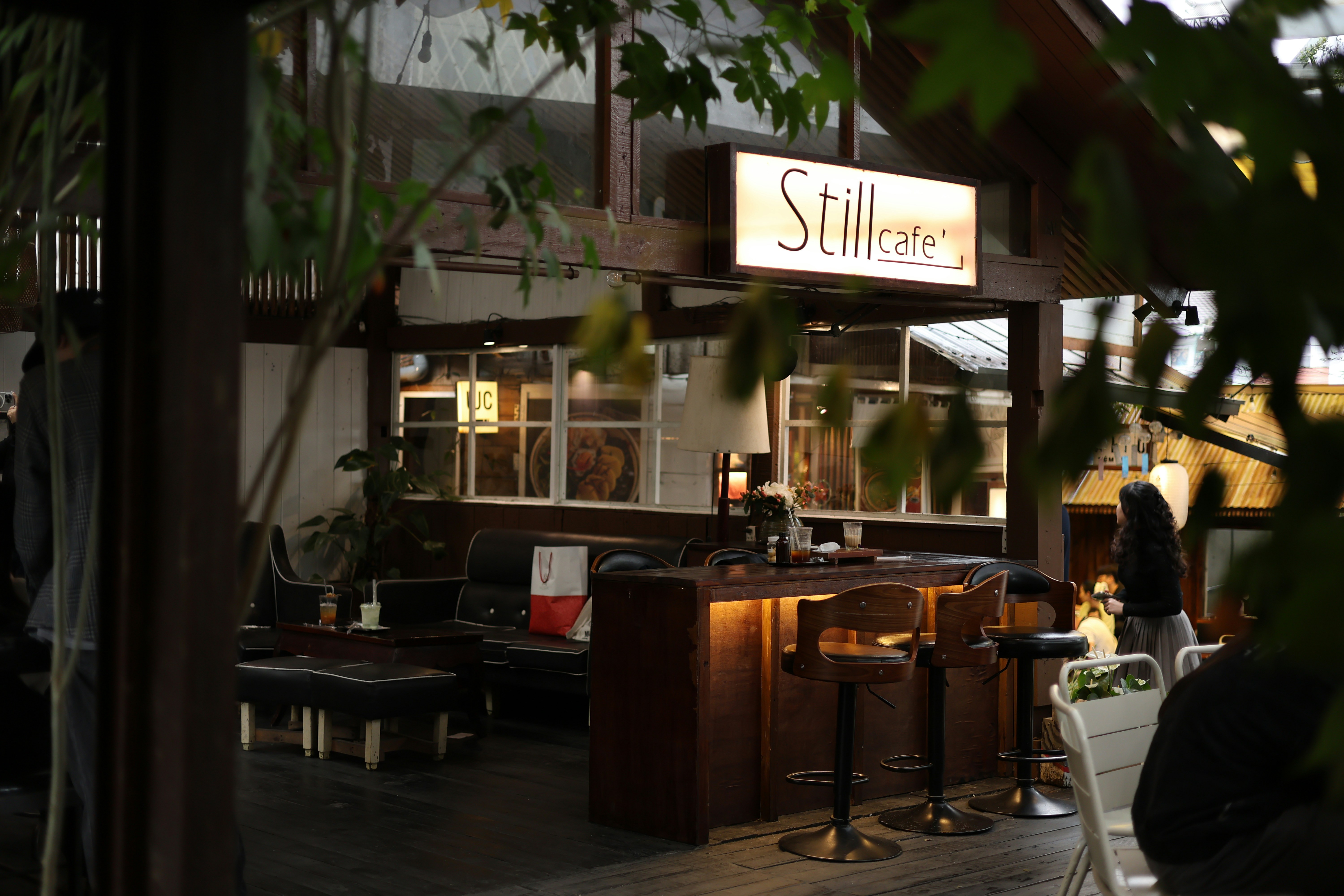 Cozy bar interior with wooden counter and stools.