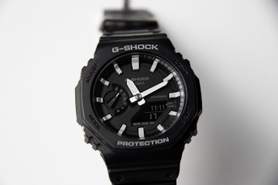 A black g-shock watch with a white dial.