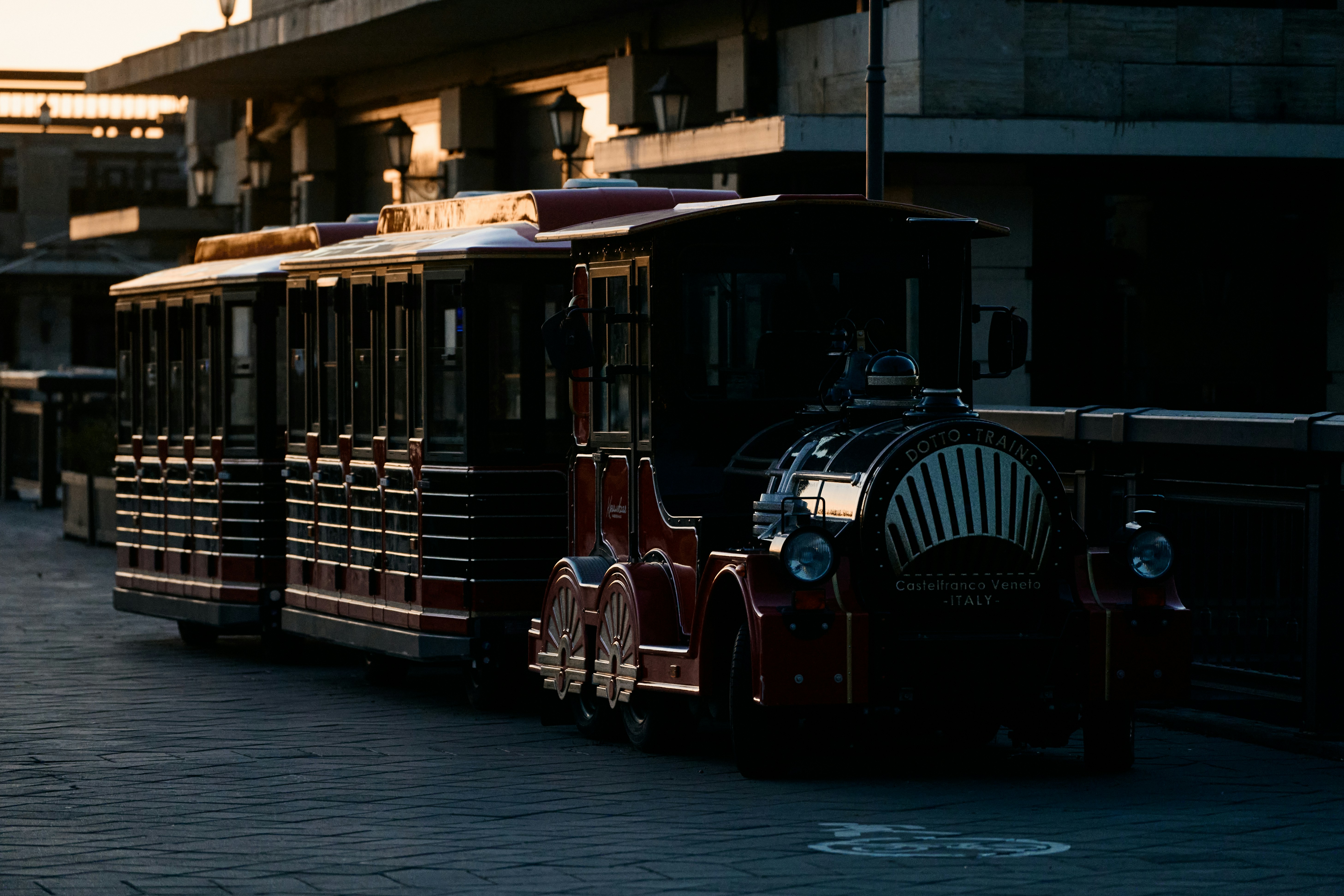 Un train d’époque avec plusieurs wagons dans une rue.