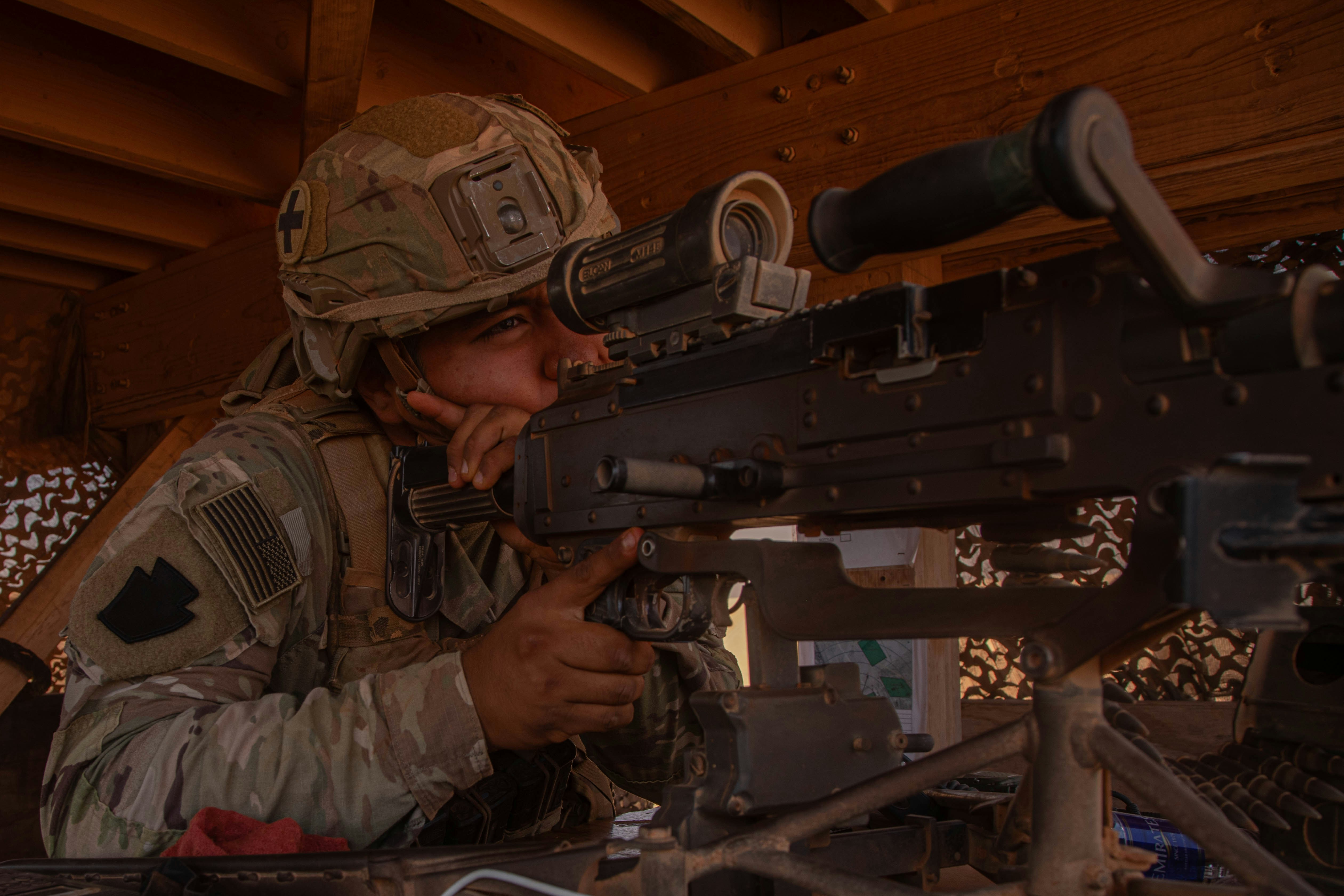 兵士はスコープを通して重機関銃を狙います。