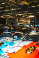 Race cars in a pit stop garage with mechanics