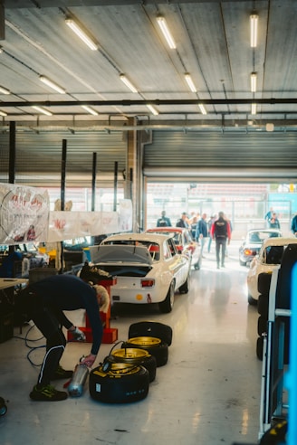 Race cars being serviced in a garage pit stop.