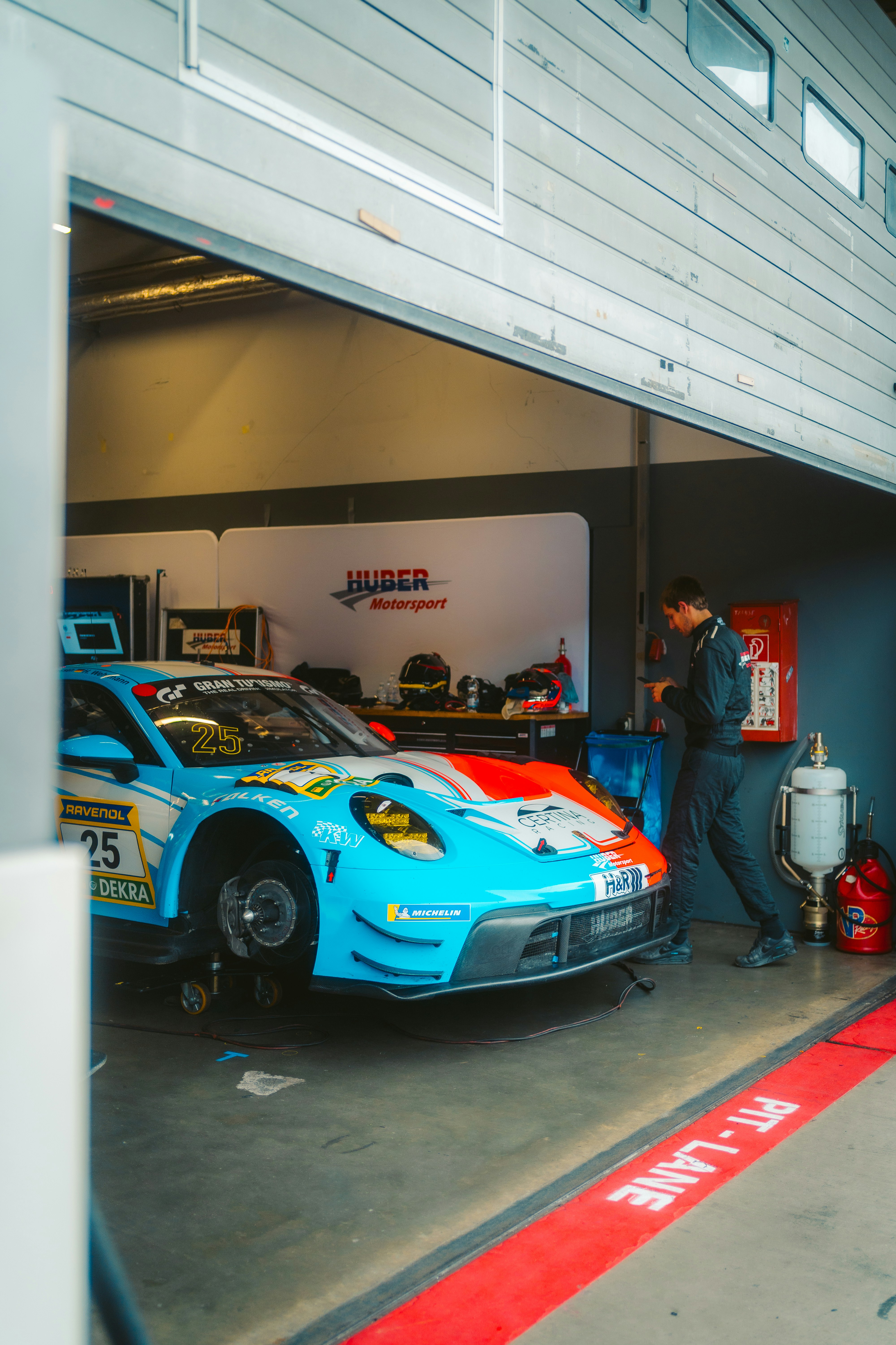 Race car being worked on inside a garage pit.