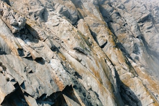 Jagged rock face with striations and mineral deposits.