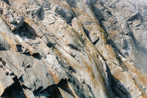 Jagged rock face with striations and mineral deposits.