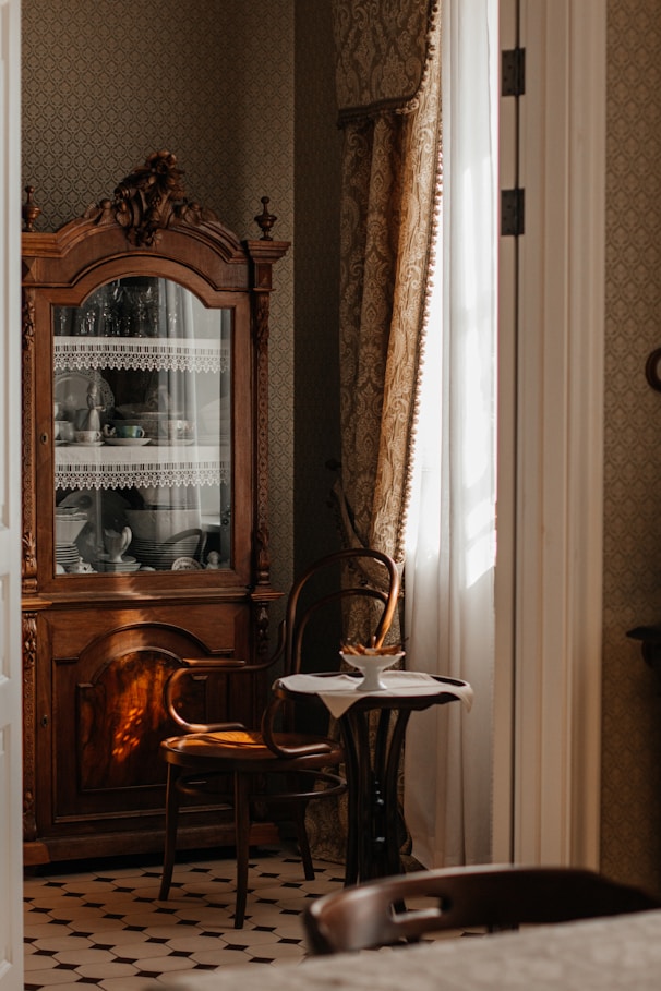 Antique cabinet with chair and small table.