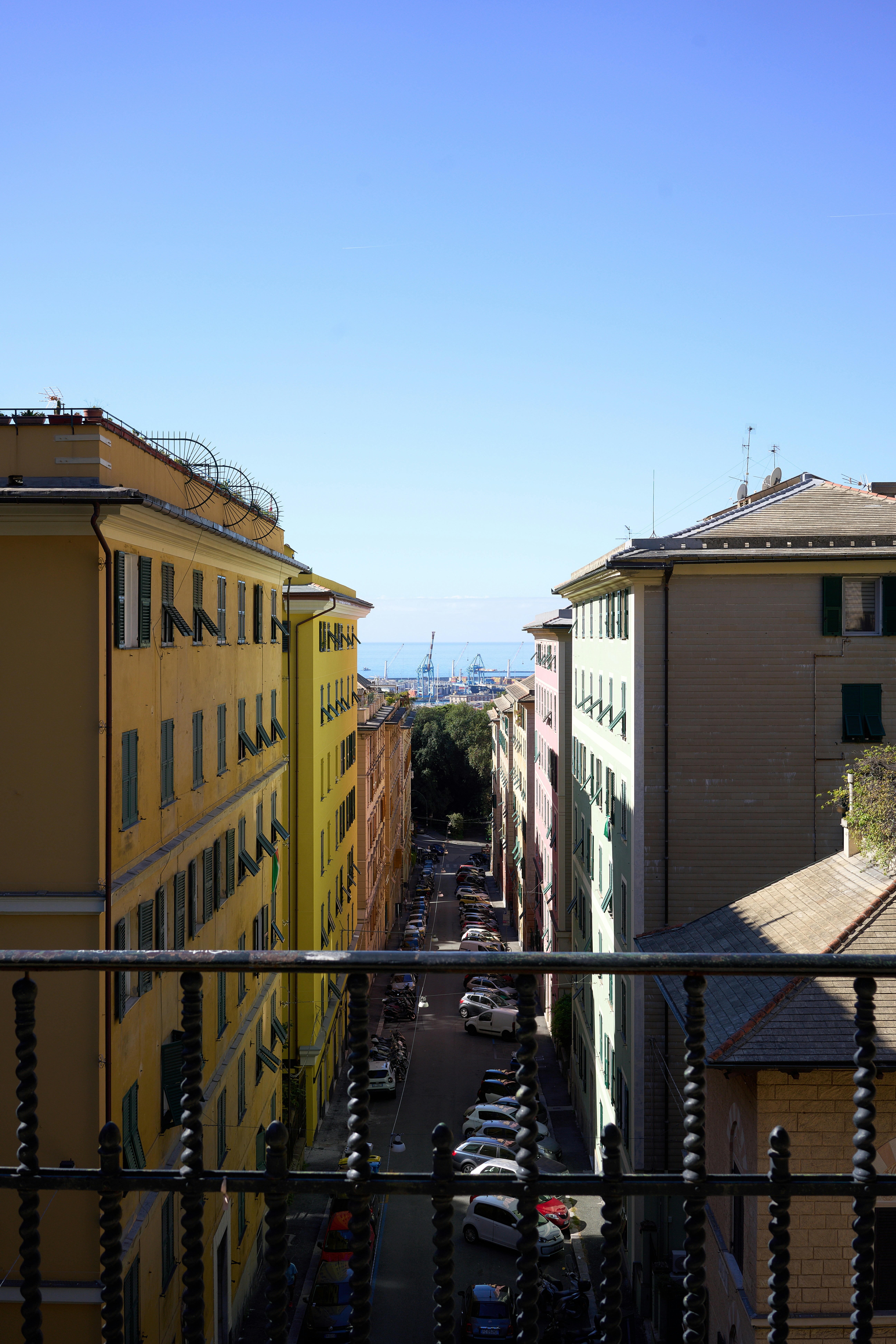 Colorful buildings line a street leading to the ocean.