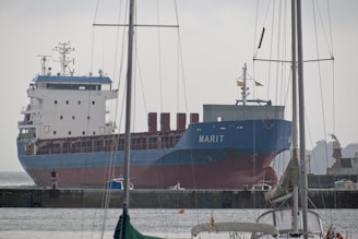 Large cargo ship named marit docked at harbor.
