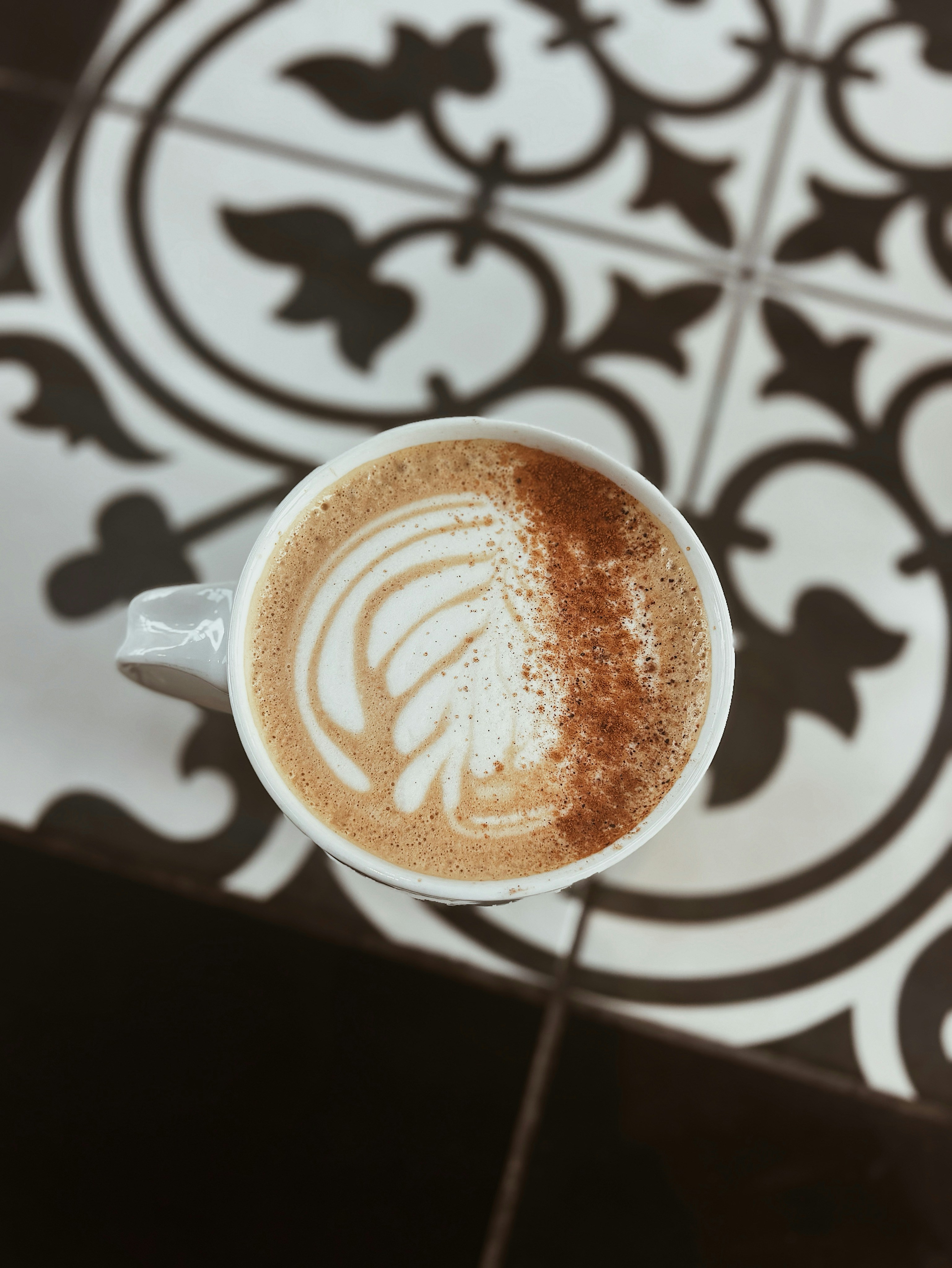 A cup of coffee with latte art and cinnamon.