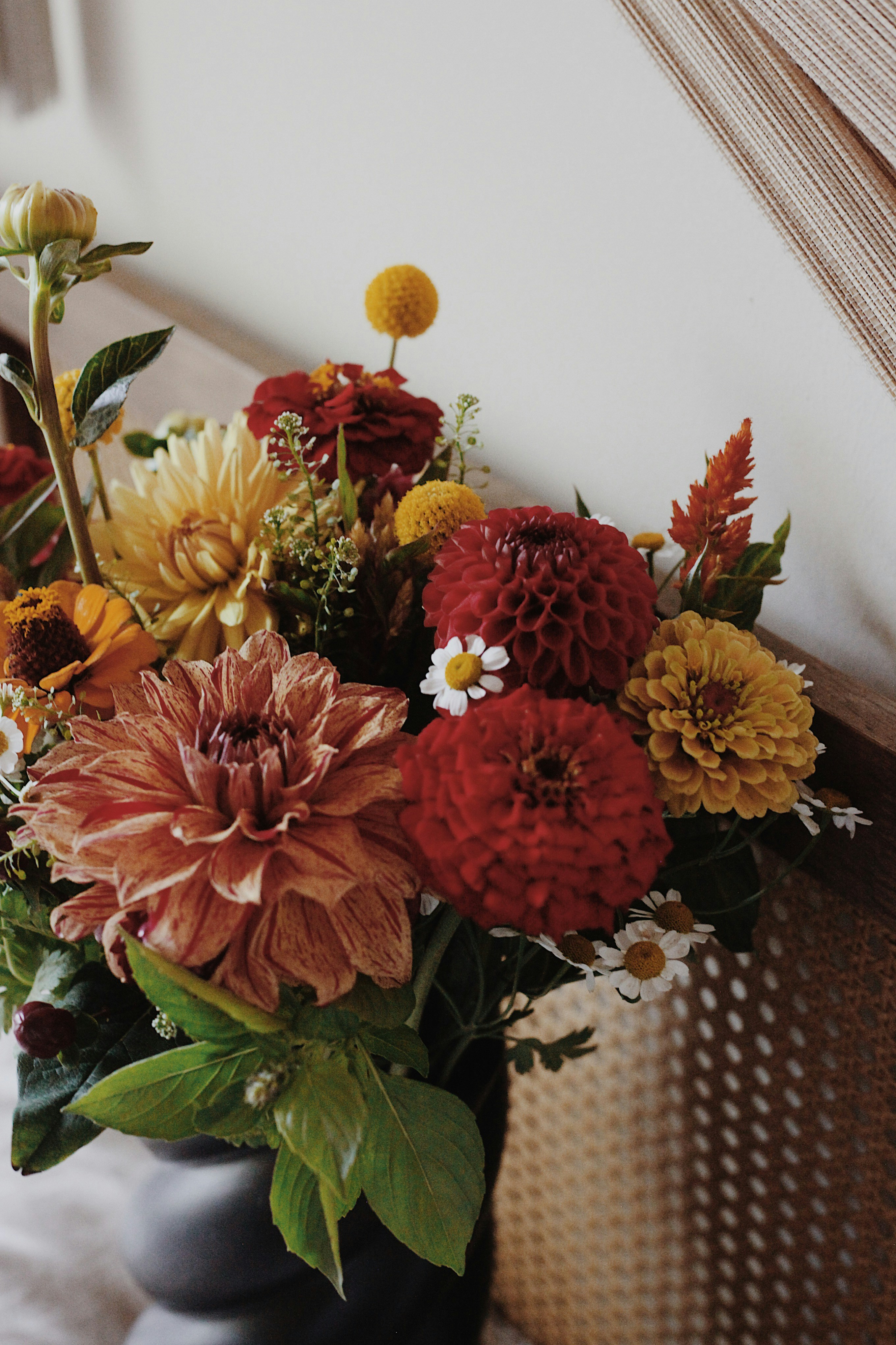 A vibrant bouquet of dahlias and daisies in a vase.