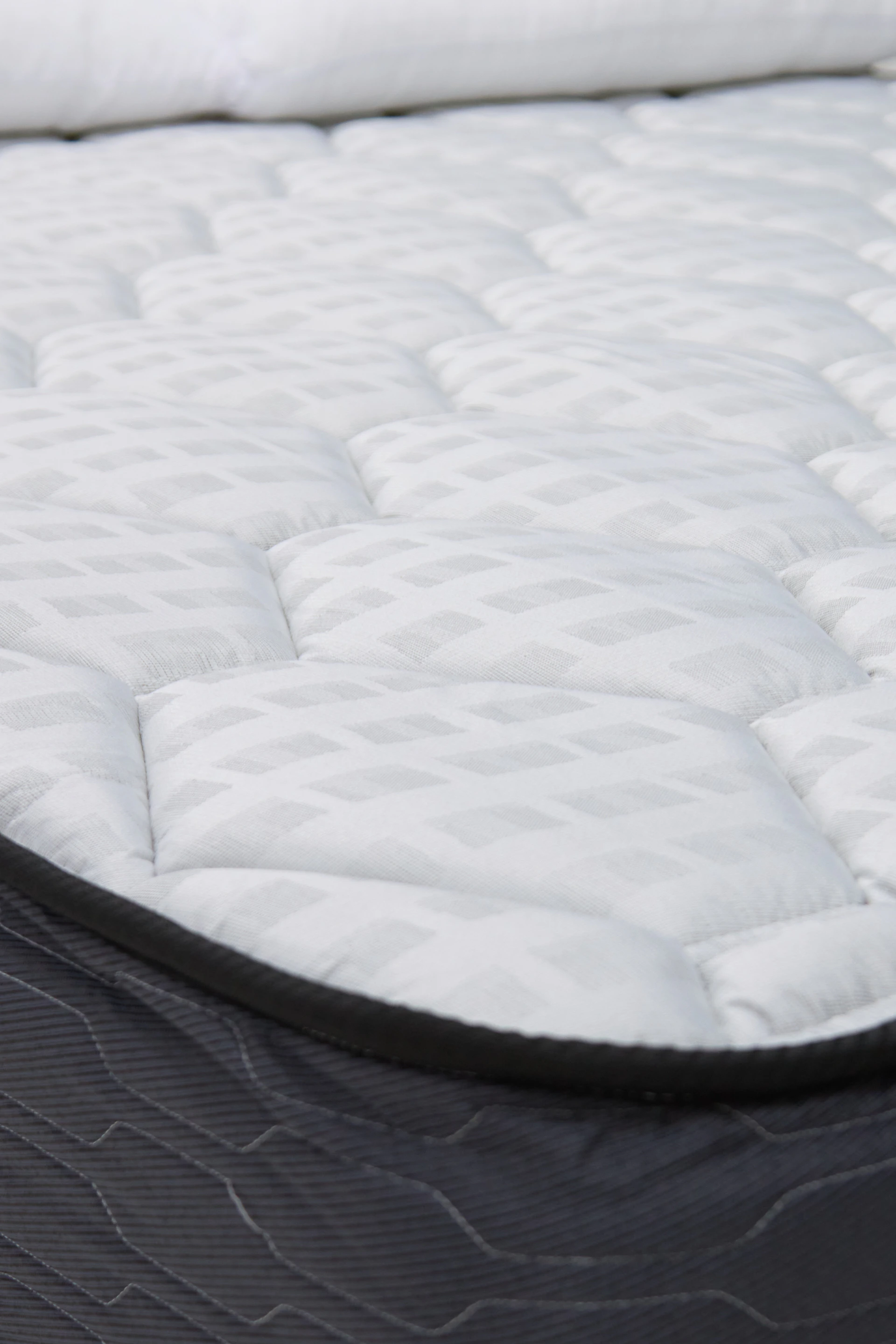 Close-up of a white quilted mattress top