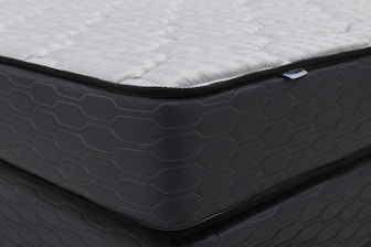 Close-up of a modern mattress with a dark patterned base.