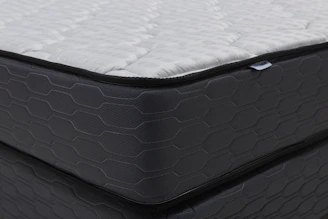 Close-up of a modern mattress with a dark patterned base