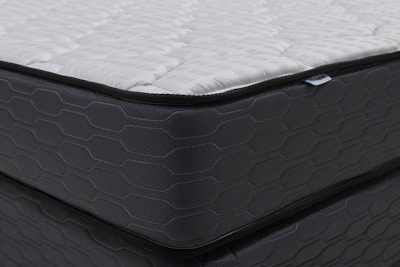 Close-up of a modern mattress with a dark patterned base.