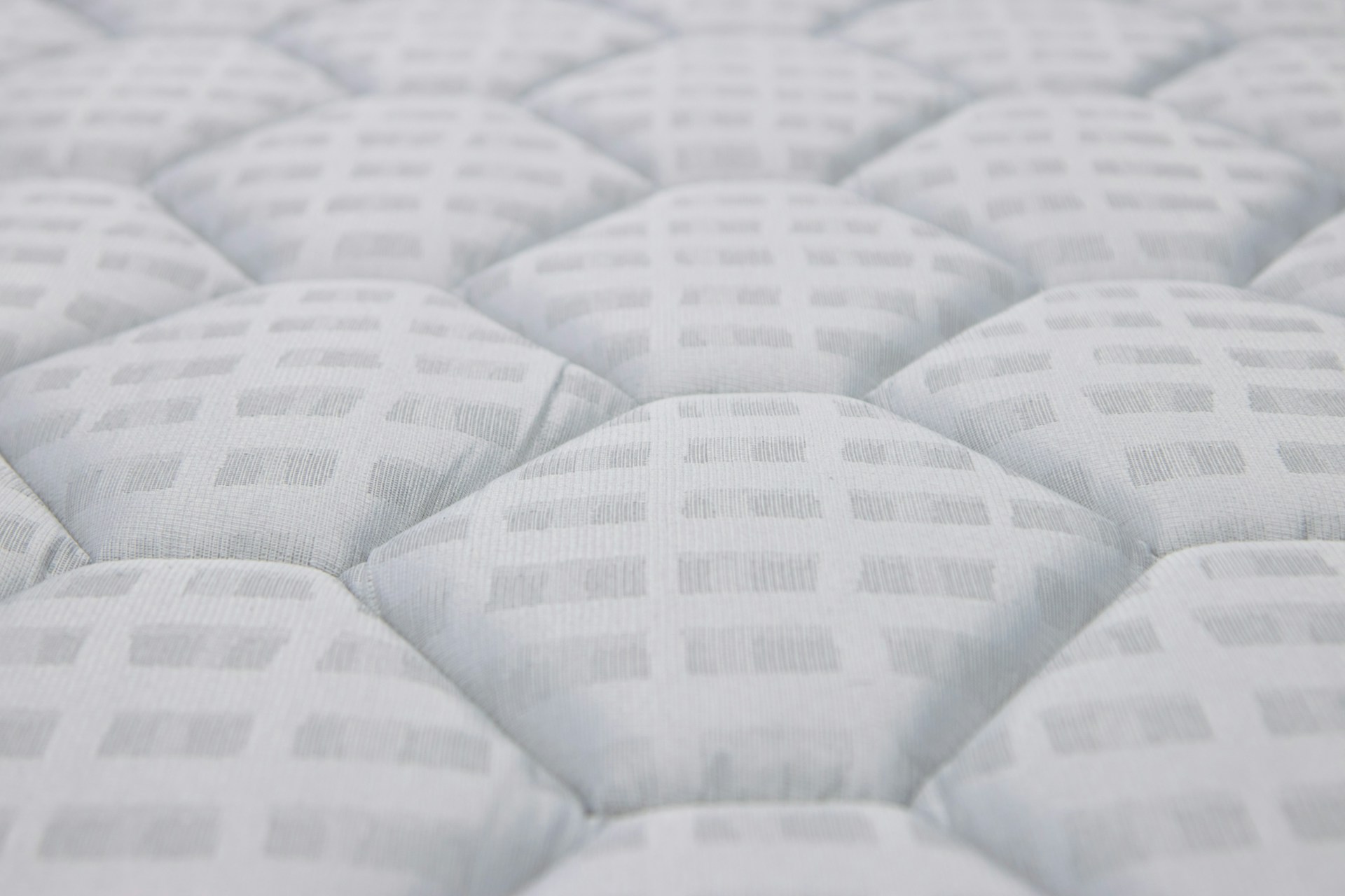 Close-up of a white quilted mattress texture