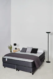 A modern bed with pillows and a blanket.