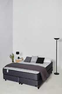 A modern bed with pillows and a blanket.