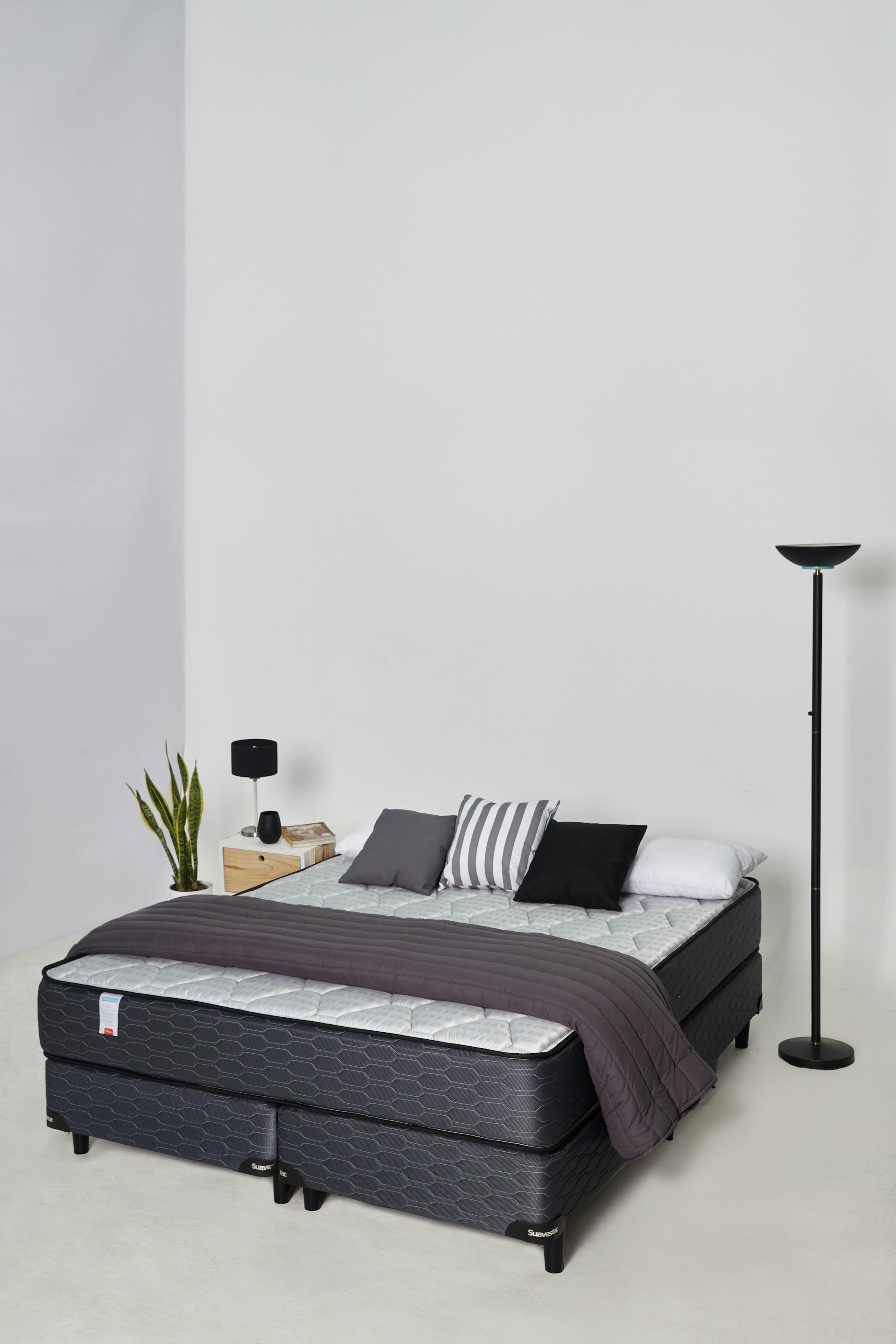 A modern bed with pillows and a blanket.