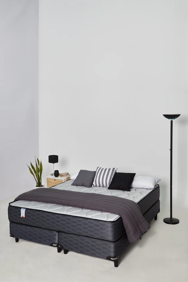 A modern bed with pillows and a blanket.
