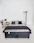A bed with a mattress, pillows, and blanket