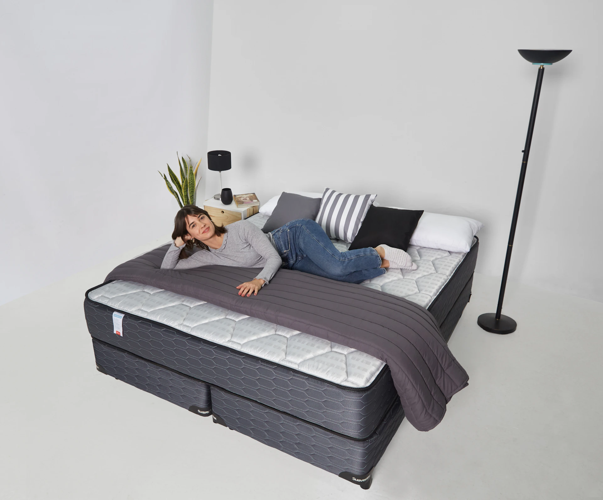 Woman relaxing on a large bed with pillows