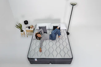 Woman relaxing on a mattress with headphones on.