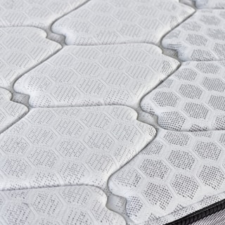 Close-up of a quilted mattress surface with hexagonal pattern.