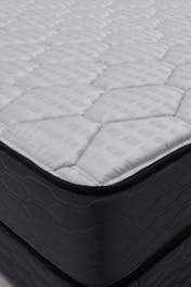 Close-up of a quilted mattress with dark sides.